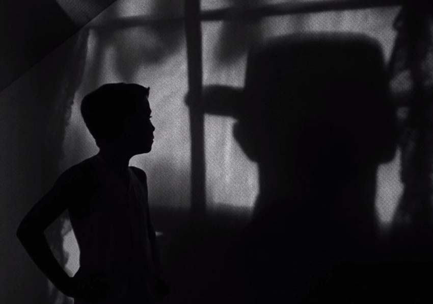 event image:A boy in profile and a man with a hat on his back